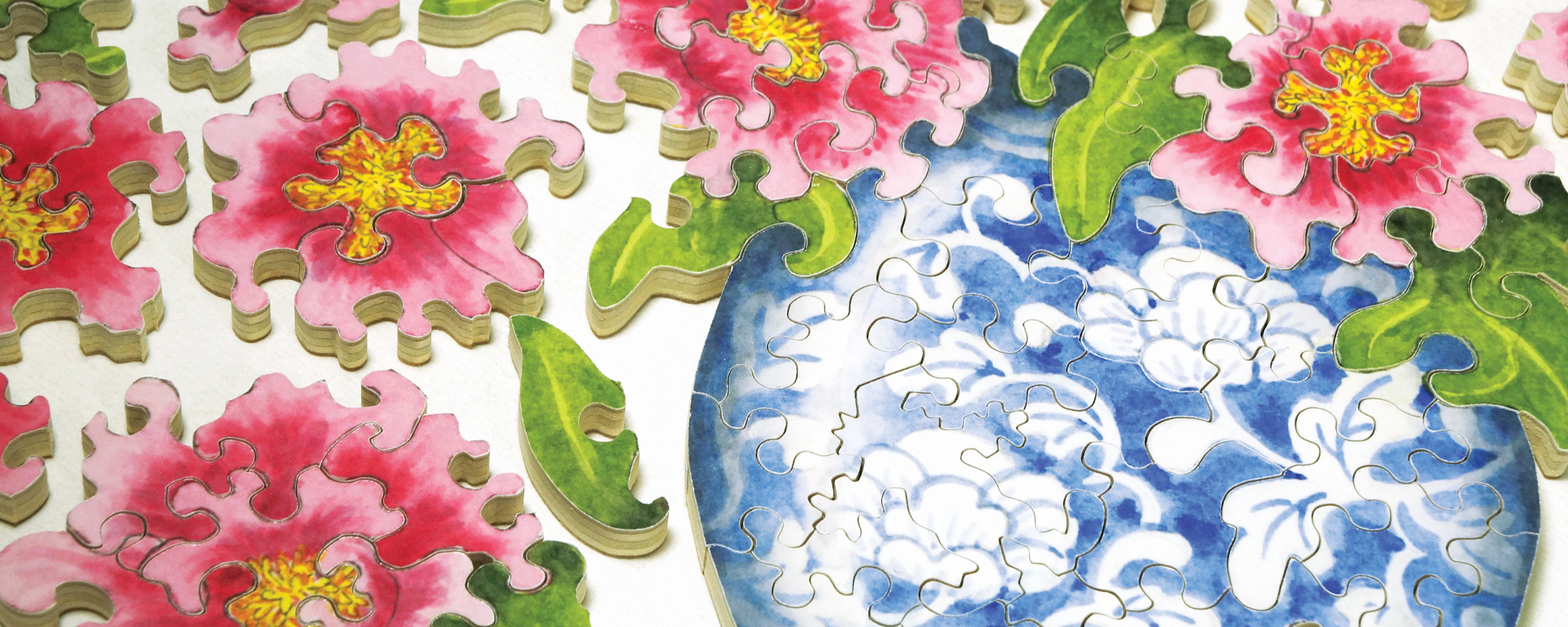 Wooden jigsaw thinking of you puzzle featuring a close up of pink flowers and a blue China vase.